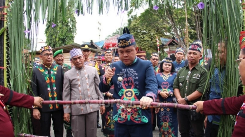 Pj Bupati Barito Selatan (Barsel), Kalimantan Tengah (Kalteng), Dr. H. Deddy Winarwan, meresmikan Rumah Adat Dayak di Buntok dengan prosesi pemotongan tali adat, disaksikan oleh tokoh adat dan masyarakat. (foto: Geloranews.co/dok)
